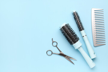 Hair brushes with scissors on blue background