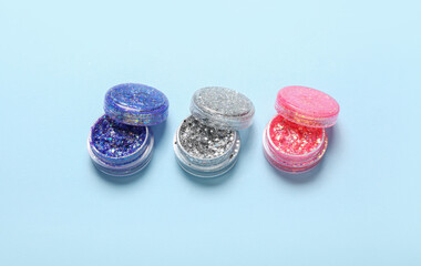 Jars of glitter on blue background