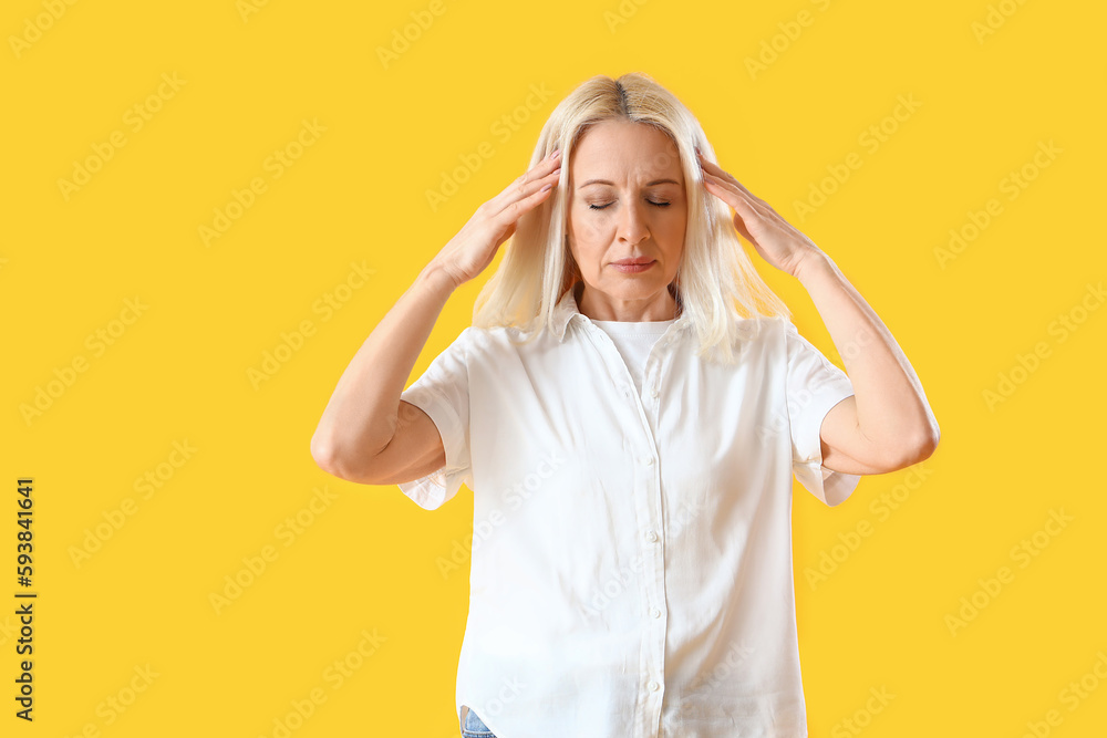 Poster Thoughtful mature woman on yellow background