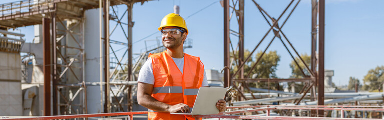 Worker with safety equipment working at heavy industry plant