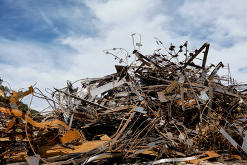 A large pile of rusty scrap metal in a landfill outside the city.