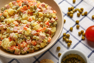 Bowl of tasty Olivier salad on table, closeup