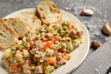 Plate of tasty Olivier salad on grunge background, closeup