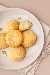 Plate with tasty choux dessert on beige background