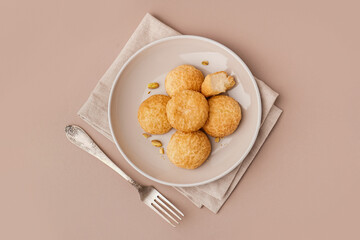 Plate with tasty choux dessert on beige background