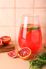 Jug of tasty blood orange lemonade on table