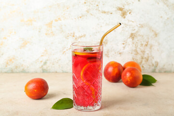 Glass of tasty blood orange lemonade on light background