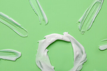 Sun made of sunscreen cream on green background, closeup