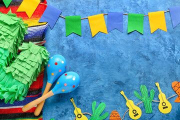 Frame made of Mexican maracas, pinata, garland and flags on grunge background