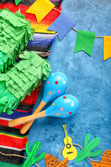 Mexican maracas with pinata, serape and flags on grunge background, closeup
