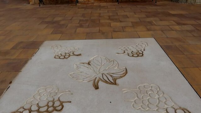 Imprinted grapes and vine leaf set in concrete on stone floor of Aranda de Duero, Burgos. Tilt up