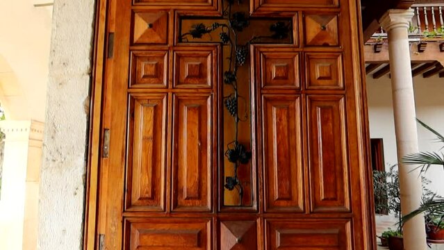Old wooden door with a cross made of vines in Santuario Virgen de las Vinas, Burgos