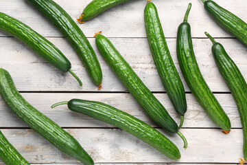 Fresh cucumbers on light wooden background