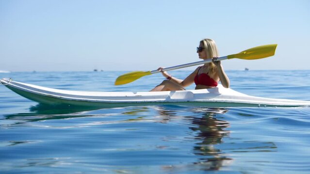 girl traveler swims in kayak boat in tranquil sea