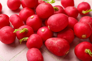 Heap of fresh radish on pink tile background, closeup
