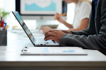 Hands of entrepreneur working on laptop at office desk