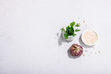 Kitchen cooking background with fresh parsley, garlic and sea salt. Hard light, dark shadow