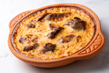 Tave kosi is a national Albanian dish of baked lamb and rice with yoghurt close-up in a pan on the table. horizontal top view from above. Turkish name; Elbasan tava - obrazy, fototapety, plakaty