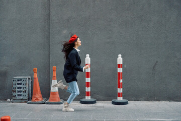 Fashion woman running down the street in front of the city tourist in stylish clothes with red lips and red beret, travel, cinematic color, retro vintage style.