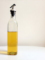 oil dispenser bottle filled with half edible refined oil for cooking and frying food items. A glass bottle with a lid to pour the oil comfortably healthy unhealthy fatty food recipe to be made from it