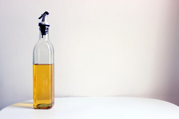 oil dispenser bottle filled with half edible refined oil for cooking and frying food items. A glass bottle with a lid to pour the oil comfortably healthy unhealthy fatty food recipe to be made from it