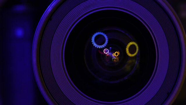 Colored lights moving in a camera lens reflection, photographic objective glass under low light, artsy conceptual video concept.