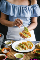 Mexican woman hands preparing tacos al pastor and eating traditional mexican food in Mexico Latin America, hispanic people