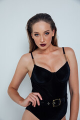 Fototapeta premium a woman in a black swimsuit bodysuit on a white background