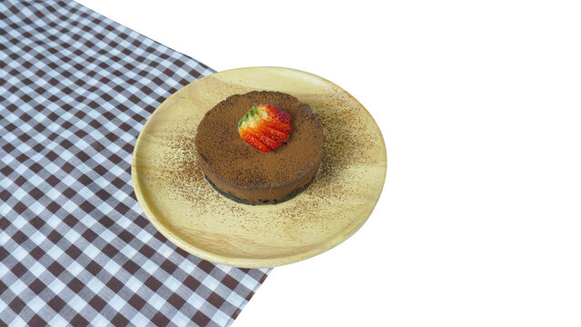 Chocolate cake top up with strawburry on a wood plate and black check tabke cloth isolated background.