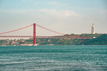 the Cristo Rei Statue and the Ponte 25 de Abril or 25the April Bridge at the Rio Tejo near the City of Lisbon in Portugal. Portugal, Lisbon