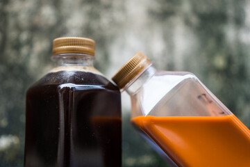 Black coffee and Thai milk tea in a plastic bottle with a golden lid. The concept of take home