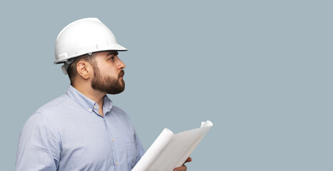 hombre de la construcción de casco blanco con un plano en sus manos con espacio para texto
