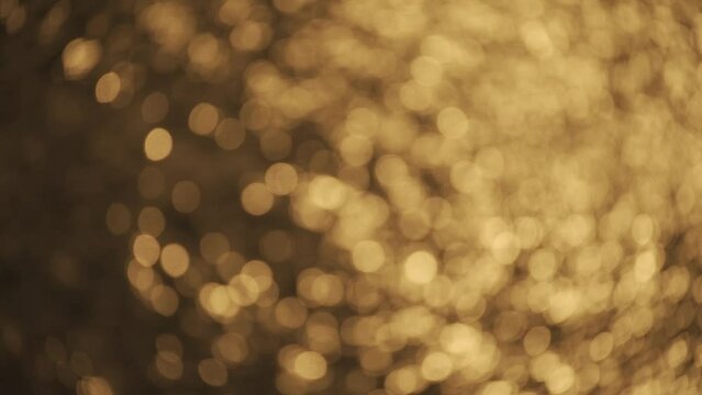 Blurred bokeh golden sea at sunset. The sun reflects and sparkles on the waves. HLG BT.2020
