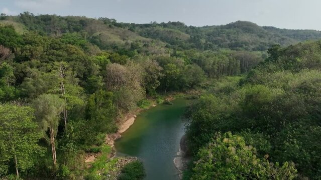 Drone passing along sections of the River Oyo near the Gantung Wanagama Bridge (Jemabatan) at the start of the dry season - with matching foliage.  Passing over or near to the bridgee