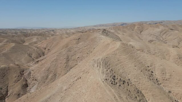Aerial drone reveal desert mountains along the ridge  in the desert near Arad and the dead sea, Negev, Israel with dramatic scenery during sunny day with blue sky in winter
