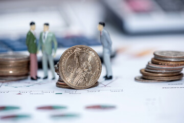 Miniature people with us coin on business graph chart