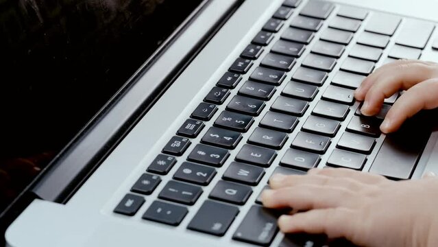 Todler hands trying ti type on laptop keyboard, playing games since childhood. Problem with new technology and growing of a child