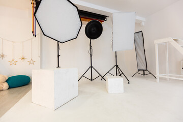 Empty photo studio with lighting equipment.