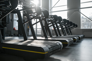 Treadmills set at modern fitness club, professional sport gym interior