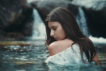 Woman immersed in mountain stream
