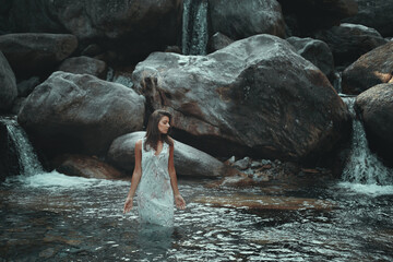 Woman in a mountain pond with waterfalls