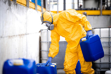 Working in chemicals factory warehouse carrying acid tanks.
