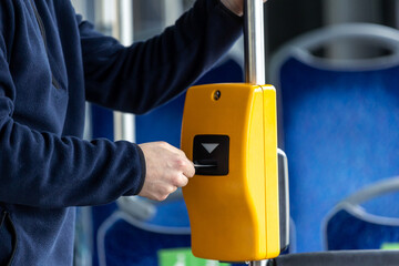 Young man hand inserts the bus ticket into the validator, validating and ticking