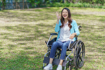 Fototapeta na wymiar Young asian woman in wheelchair with positive thinking.