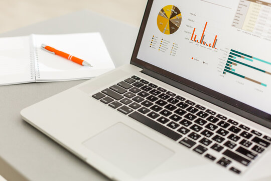 Home office. laptop screen with charts and diagrams - Powered by Adobe