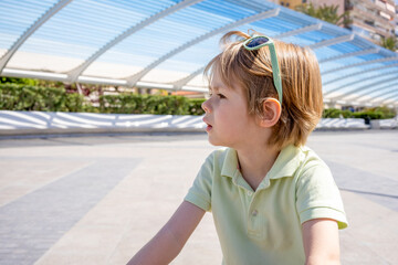 side view of a blonde little boy in a park outdoors