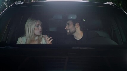 View through the front window of a car. The couple swears in the car. The boy and girl are arguing and screaming at each other. The tension between the partners was high. The girl is waving her hands.