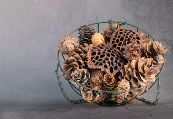 Dried pine cones and lotus seeds are placed in an iron basket.
