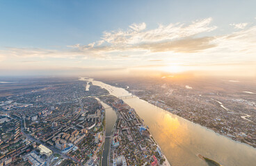 Fototapeta na wymiar Astrakhan, Russia. Panorama of the city from the air in summer. The Volga River and Gorodstoy Island. Sunset time. Aerial view