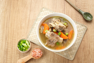 Sop Iga (Beef ribs soup) made from ribs, carrots, leeks.  Served in white bowl. Indonesian food
